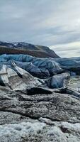 glaciar excursionismo vatnajokull hielo gorra en Islandia con congelación frío glacial bloques en escandinavo grande lago, islandés paisaje. majestuoso ártico icebergs cerca marrón escarchado colinas y Nevado campos. foto