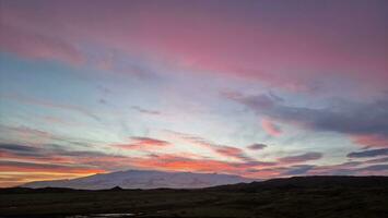 islandés nórdico de colores cielo a atardecer, hermosa rosado y amarillo nubes pintura mágico nórdico escenario. majestuoso escandinavo ver de rosado algodón caramelo ligero debido a Dom ajuste encima montaña. foto