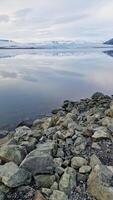 escarchado abierto agua y Nevado pendientes en islandés configuración, escandinavo congelado lago dentro nórdico Islandia paisaje. majestuoso paisaje con rock formaciones y hielo fragmentos foto