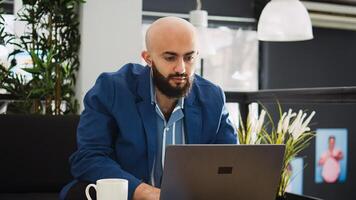 Manager comparing data on laptop and working in startup coworking space. Small business employee standing near workstation, analyzing statistics report for programming. Agency CEO. photo
