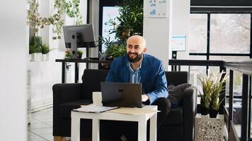 Middle eastern employee in office, professional consultant working on laptop to solve tasks. Company manager reading official documents and programming statistics data, entrepreneurship. photo