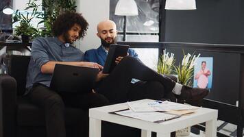 Two managers checking reports and official documents in coworking space office. Smiling entrepreneurs team working together on development plan for small business project, collaboration. photo