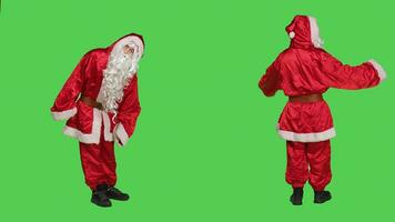 Impatient santa claus looks at time on wristwatch, trying to be punctual while he stands over full body greenscreen. Saint nick character with white beard spreading christmas spirit. photo