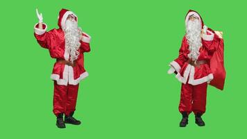 Saint nick creating marketing ad in studio, working on christmas eve holiday advertisement to spread december spirit. Person in santa suit pointing left and right to advertise something. photo