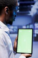Specialist investigating performance trends in data center mainframes. Manager using chroma key tablet to identify operational challenges in server room contributing to hardware malfunction, close up photo