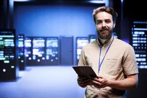 Portrait of technician making sure servers in cloud computing business service are correctly equipped, to provide redundancy and automatic failover of clusters to minimize failure of hardware photo
