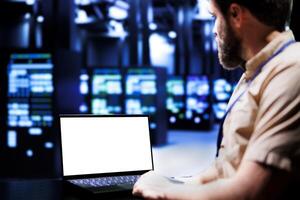 Expert using mock up laptop to evaluate supercomputers with high computing power enabling server room to support demanding applications, including virtual reality and video rendering workloads photo