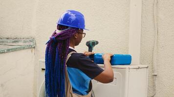 African american expert preparing for routine hvac system checkup. Efficient technician unpacking toolkit with professional instruments needed to clean clogged air filters restricting airflow photo