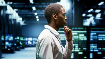 System administrator monitoring supercomputer cybersecurity threats arising due to unsecured network connections. Supervisor making sure server hub is invulnerable to DDoS attacks photo