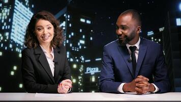 Journalists team on late night talk show covering all celebrity news and events, creating entertainment and media content live on tv network. Man and woman hosting midnight panel in studio. photo