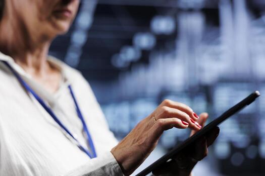 Senescent IT manager using tablet, ensuring valuable data remains shielded from potential perils, safeguarding supercomputers against unauthorized access and vulnerabilities, close up photo