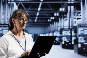Senior specialist preparing server room recovery plan monitoring data center energy consumption across parts, making sure sensors are functioning optimally, doing yearly disk checks photo
