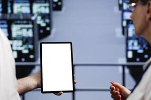 Close up of mock up tablet used by collaborating colleagues in cloud computing business server farm delivering massive computational power, capable of processing and storing vast amounts of datasets photo