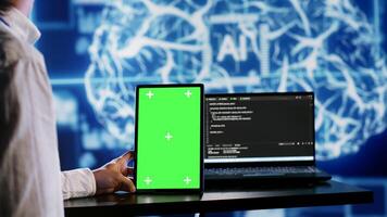 Certified admin using green screen tablet to write artificial intelligence script code in startup workspace. Qualified expert doing maintenance work in high tech establishment updating AI systems photo