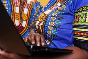 African american people holding laptop in hands and using touchpad closeup. Black man and woman using portable computer together and typing on keyboard with close view on arms photo