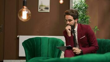 White collar worker using laptop in lobby, reviewing speech notes to present financial information in front of shareholders. Elegant hotel guest travelling on business trip abroad. photo