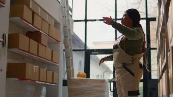 Manager in warehouse using AR holographic technology to visualize how to best stash parcels on shelves to make room for more. Supervisor in distribution center uses augmented reality photo