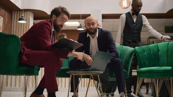 Entrepreneurs meet in hotel lobby, looking over finacial data on files before presenting statistics on official meeting. Associates discussing about partnership and sharing ideas for common goal. photo