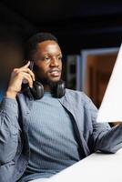 At home, investment banker studies equity balance statement sheets while engaged in remote tasks and discussing on call with director. Analyst uses revenue tracking records to boost profit. photo