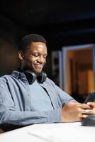 Male developer checking social media app on phone, texting messages while he is attending online e learning courses. Young adult sending sms on smartphone, reading news on internet. photo