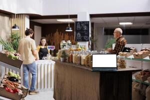 Isolated screen laptop used in zero waste supermarket by vendor to promote additives free products. Commercial empty copy space on mockup device acting as advertisement in local bio food store photo