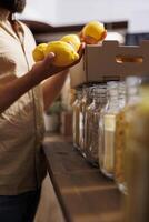 Client purchasing nutritious lemons grown by zero waste supermarket owner in his garden. Vegan customer happy to find eco friendly additives free fresh fruits in local store, close up photo
