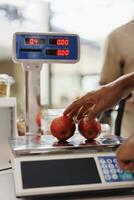 In an eco-friendly store, an electronic scale is used to weigh organic produce grown without synthetic food additives. Cashier using weighing machine in a local grocery store. photo