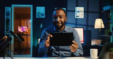 Content creator filming tech review of newly launched tablet, unboxing it and presenting specifications in home studio. Internet star showing digital device to viewers, offering performance feedback photo