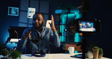 BIPOC content creator filming review of noise cancelling headphones comparison between two pairs, giving feedback on best performing one, recording video with professional camera photo