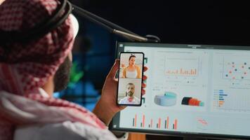 Islamic teleworker and coworkers in internet video call checking analytics statistical data sets. Arab employee optimizing key performance indicators in teleconference meeting, close up photo