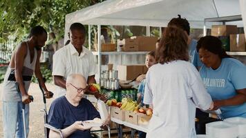 Charitable team offers help to the destitute and distributes free food including fresh fruits to homeless. A wheelchair-bound disabled individual also receives hunger alleviation assistance. photo
