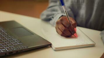 mujer tomando escrito ideas notas a hogar escritorio, molesto a encontrar Perfecto trabajo fluir y desarrollar en línea independiente carrera profesional. persona utilizando cuaderno planificación para trabajo productividad. cerca arriba. foto