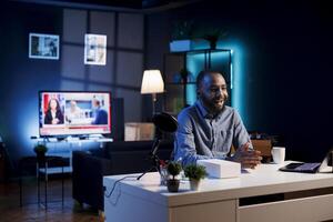 Influencer in home studio using professional microphone to record live broadcast for online streaming platforms, talking with fans. African american online star hosts q and a session with viewers photo