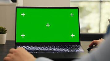 Female manager works on laptop running isolated greenscreen template, checking pc with blank mockup display. Young adult working on startup tasks using chromakey copyspace layout. photo