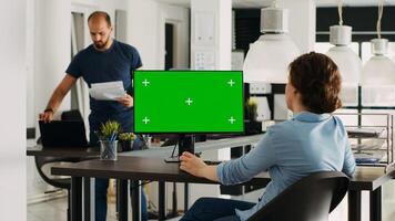 especialista mirando a pantalla verde modelo en escritorio monitor en pequeño negocio agencia lugar de trabajo. persona comprobación aislado monitor demostración blanco chromakey Bosquejo, problema resolviendo trípode disparo. foto
