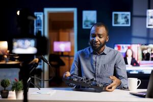 Content creator doing DJ controller review for his online streaming channel subscribers, unhappy about low quality sound output. Reviewer disappointed after testing professional sound mixer photo