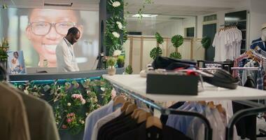 bipoc hombre trabajando en lujoso ropa Tienda con elegante surtido de chaquetas. africano americano tendero esperando clientela en prima Moda boutique con elegante atuendo vestidos foto