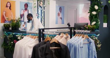 Retail assistant in stylish fashion boutique waiting to receive batch of new merchandise, imputing data on digital device. Worker in clothing store awaiting delivery of garments from new collection photo