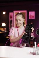 Cute girl showing viewers mechanical keyboard received from sponsoring brand to promote it. Gen Z online content creator advertising wireless gaming computer peripheral from partnering company photo