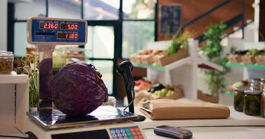 Electronic scale in eco friendly store next to organic locally grown produce. Modern weighing machine used in local neighborhood shop for bulk products and fruits or vegetables. photo