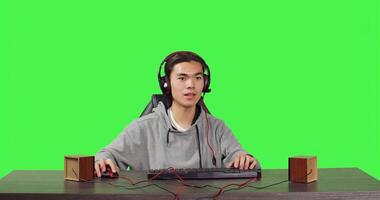 POV of adult enjoys web video games at pc while he talks to his colleagues on headphones, playing computer adventure gameplay at his desk. Young asian gamer having fun with tournament. photo