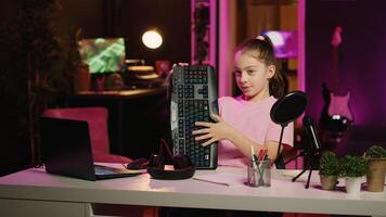 Children internet show host promoting keyboard, mouse and headphones received from sponsoring brand. Young kid star does influencer marketing, urging followers to purchase computer peripherals photo