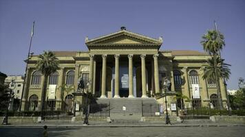 Facade of ancient building with columns and triangular portico. Action. Beautiful historical building with antique architecture and columns on blue sky background photo