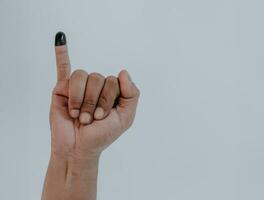 Inked pinky finger. Man hand isolated on white background. Purple ink blots from voters finger provides evidence election or pilkada Indonesia. photo