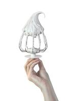 Woman's hand hold Whisk with cream, whisk with meringue cream isolated on white photo