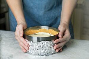 Woman making cheesecake, Making cheesecake in a baking form in the kitchen close up photo