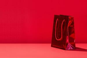 One red gift paper shopping bag on red background. Copy space for text photo