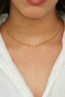 Young woman wearing a Figaro Chain Necklace containing a square zircon. photo