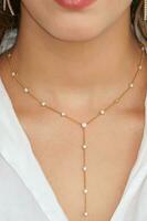 Young woman wearing a golden lariat necklace. photo