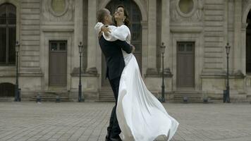 Happy just married groom carry on his hands the bridge in Paris, France. Action. Man in suit and woman in log wedding dress on the old architecture building background. photo